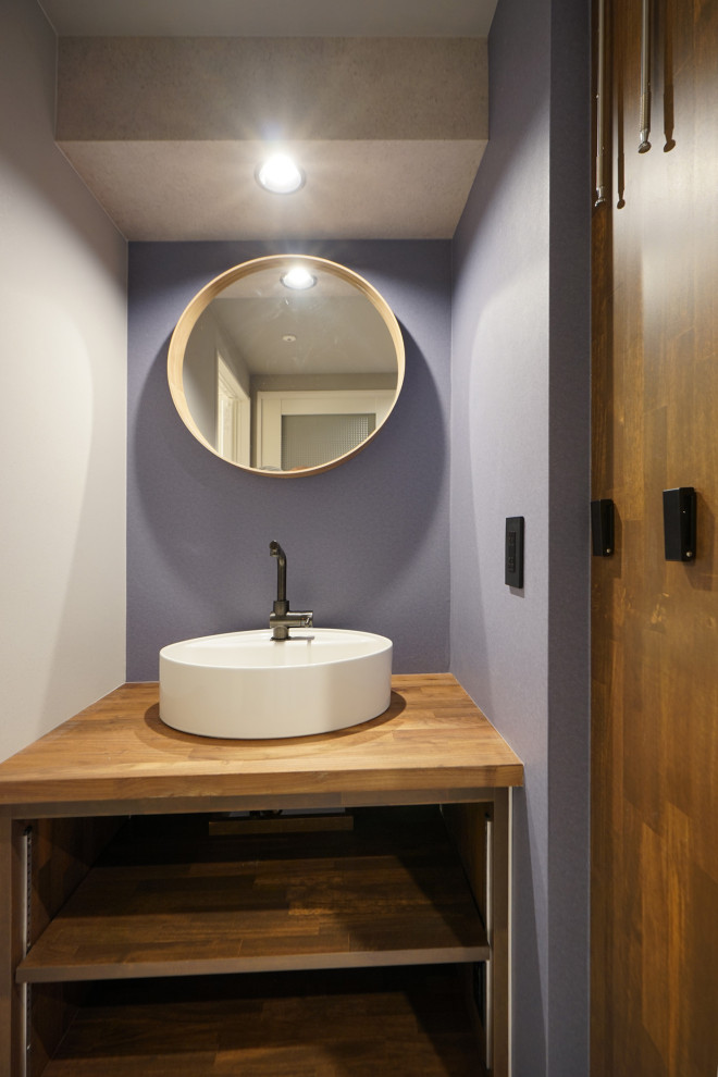 Idées déco pour un WC et toilettes en bois brun de taille moyenne avec un placard sans porte, un mur violet, un sol marron, un plafond en papier peint et du papier peint.