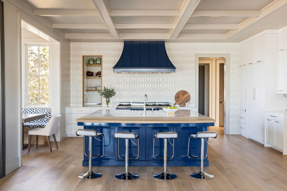 Inspiration for a large beach style single-wall eat-in kitchen in Charleston with an undermount sink, marble benchtops, white splashback, porcelain splashback, stainless steel appliances, light hardwood floors, with island, brown floor and white benchtop.