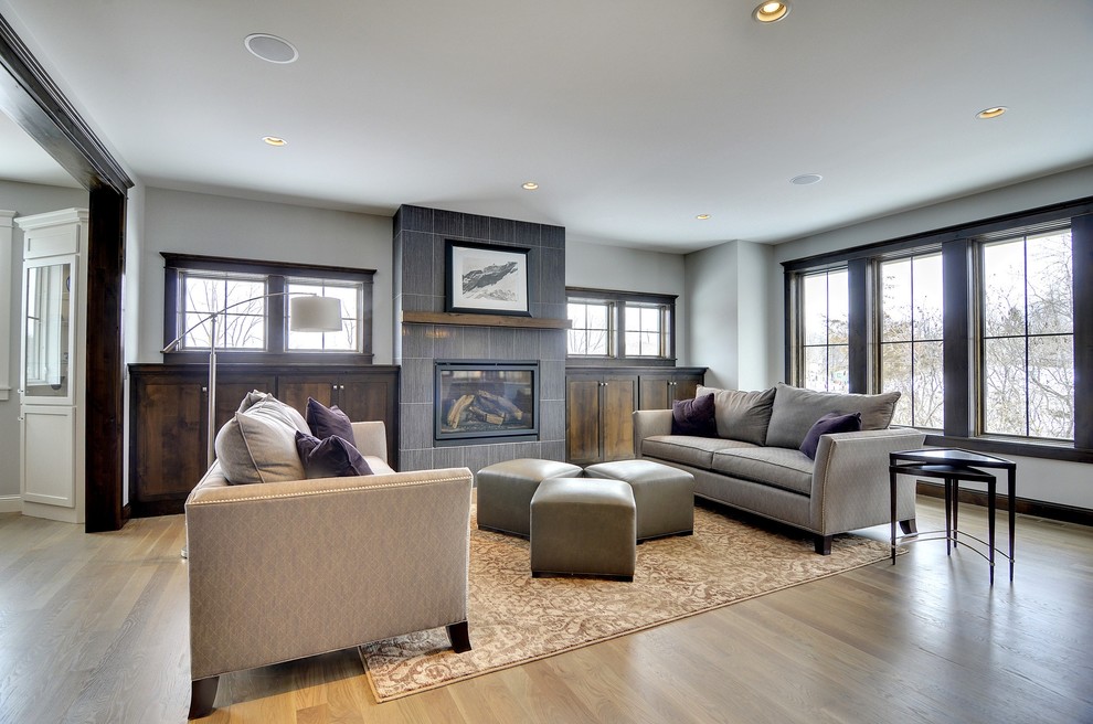 Traditional family room in Minneapolis with grey walls, medium hardwood floors and a standard fireplace.