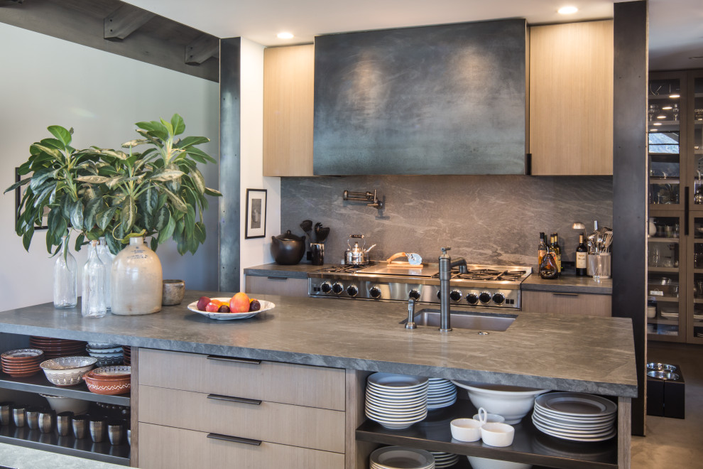 Contemporary kitchen in Other with an undermount sink, flat-panel cabinets, solid surface benchtops, grey splashback, stone slab splashback, stainless steel appliances, with island and grey benchtop.