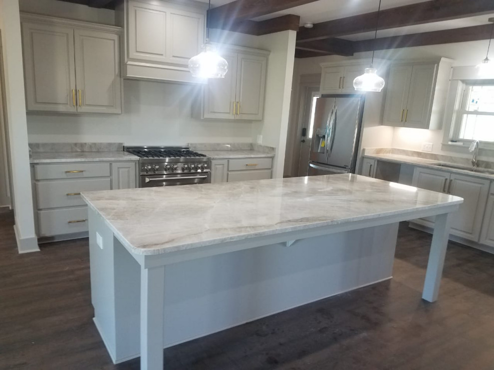 Kitchen - kitchen idea with beige cabinets, stainless steel appliances, an island and beige countertops