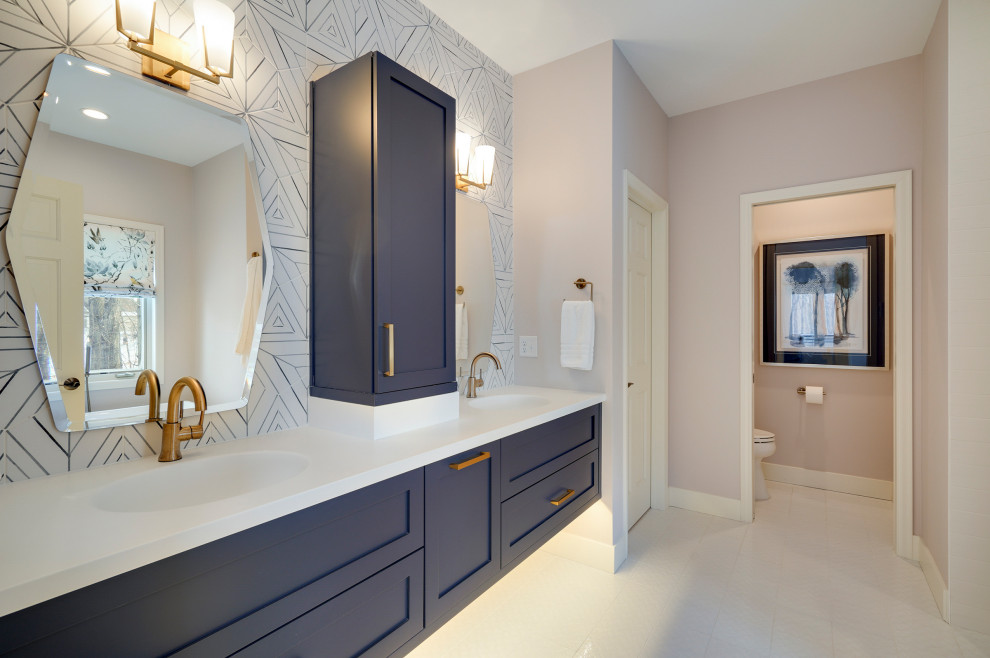 This is an example of a large classic ensuite bathroom in Minneapolis with shaker cabinets, blue cabinets, a freestanding bath, a walk-in shower, a two-piece toilet, blue tiles, cement tiles, pink walls, ceramic flooring, an integrated sink, solid surface worktops, white floors, an open shower, white worktops, an enclosed toilet, double sinks and a floating vanity unit.