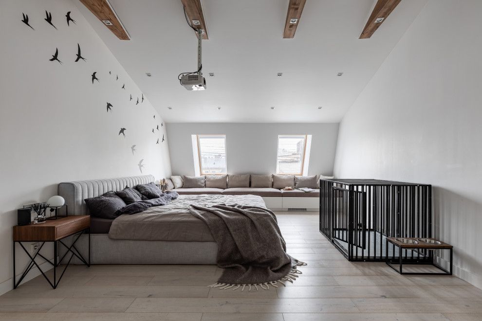 На фото: большая хозяйская спальня в белых тонах с отделкой деревом на мансарде в скандинавском стиле с белыми стенами, светлым паркетным полом, бежевым полом и балками на потолке с