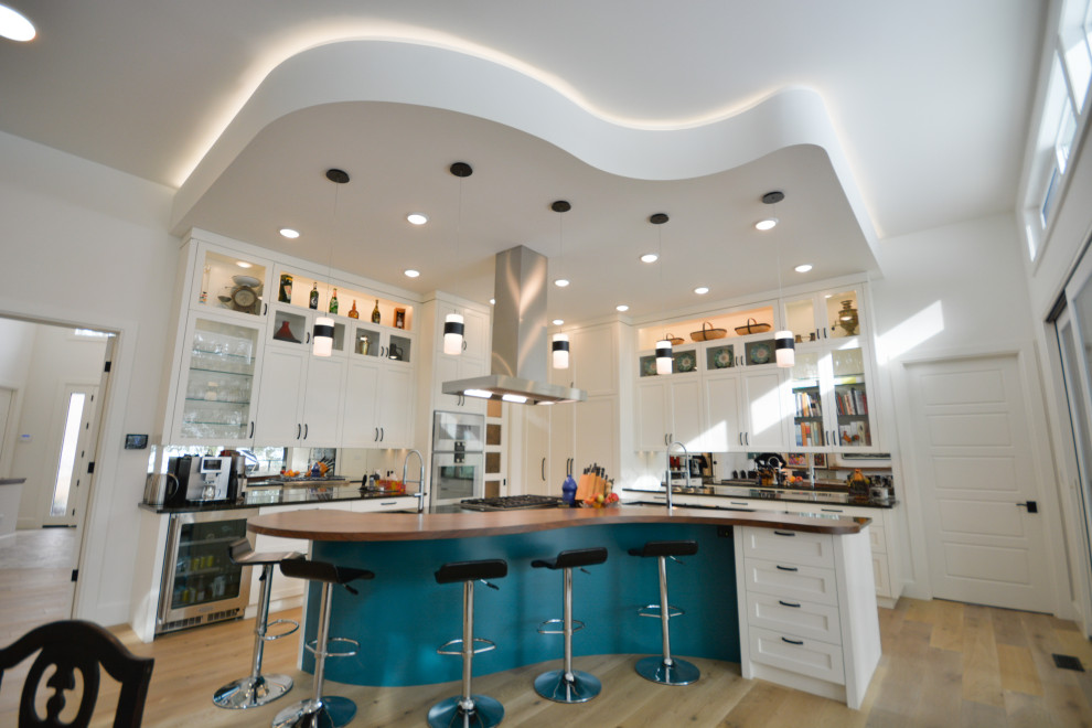 Пример оригинального дизайна: большая угловая кухня-гостиная в стиле неоклассика (современная классика) с фасадами в стиле шейкер, белыми фасадами и островом