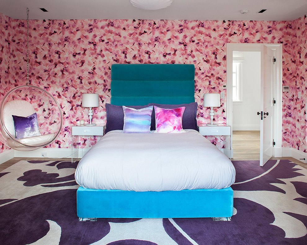 Photo of a large contemporary kids' room for girls in New York with pink walls and light hardwood floors.