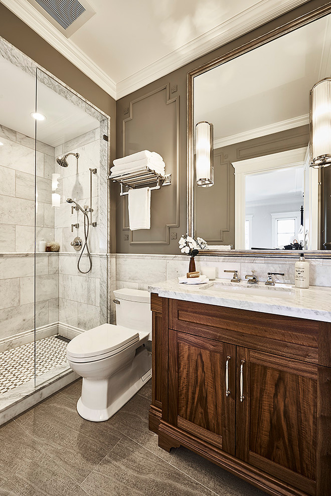 Photo of a mid-sized traditional 3/4 bathroom in Vancouver with brown cabinets, an open shower, a one-piece toilet, white tile, marble, beige walls, ceramic floors, marble benchtops, beige floor and an open shower.