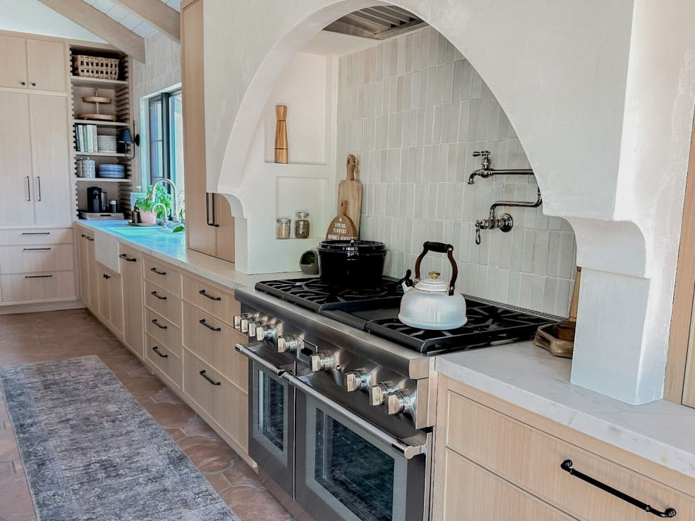 Bild på ett mellanstort funkis vit vitt kök, med en rustik diskho, skåp i shakerstil, skåp i ljust trä, laminatbänkskiva, flerfärgad stänkskydd, stänkskydd i keramik, rostfria vitvaror, cementgolv, en köksö och brunt golv