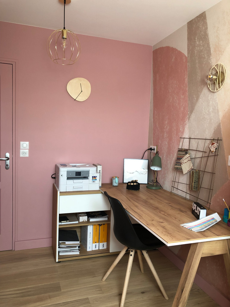 На фото: кабинет с розовыми стенами, светлым паркетным полом и обоями на стенах с