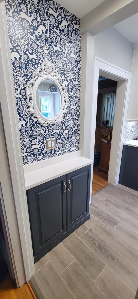 Porcelain tile enclosed kitchen photo with quartz countertops, mosaic tile backsplash, stainless steel appliances and no island