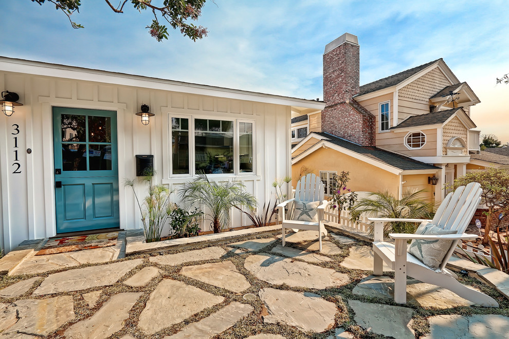 Mid-sized beach style front yard patio in Los Angeles with natural stone pavers and no cover.