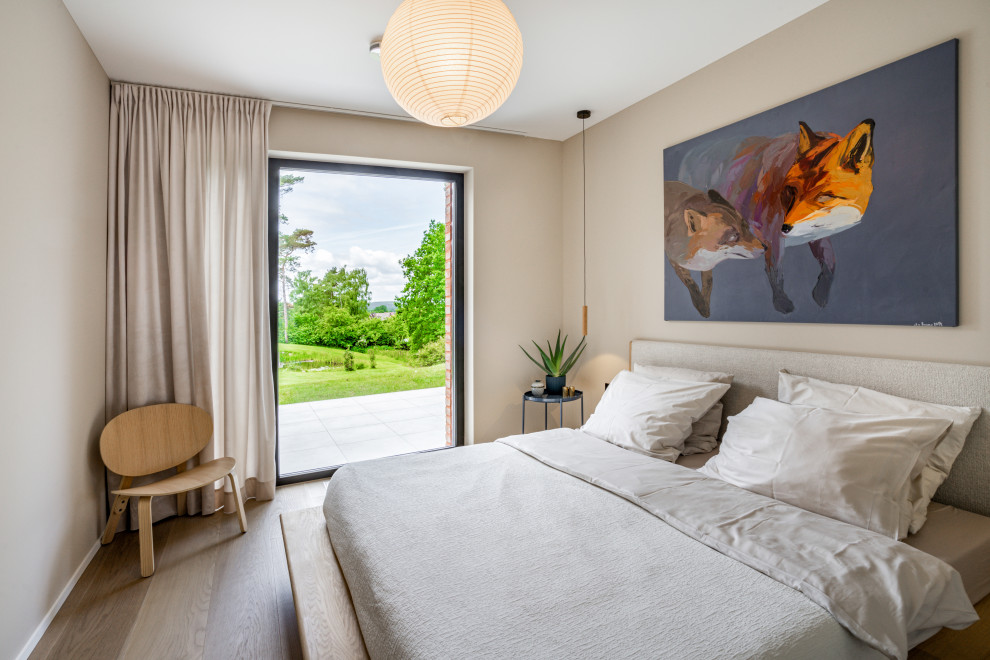 Esempio di una piccola camera matrimoniale minimalista con pareti beige e parquet chiaro
