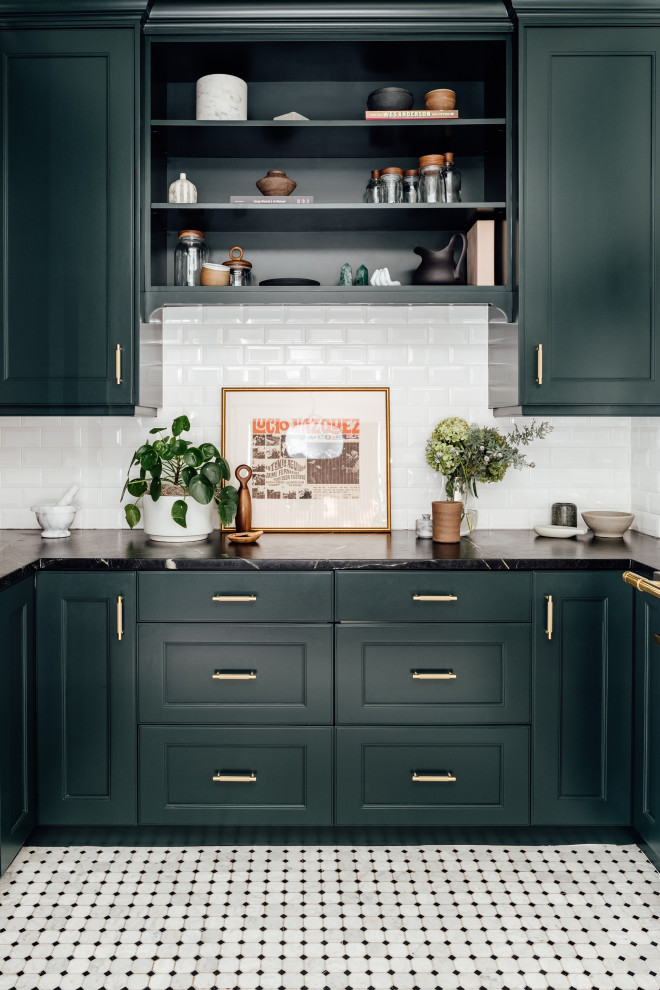 Design ideas for a mid-sized eclectic u-shaped separate kitchen in Salt Lake City with a farmhouse sink, shaker cabinets, blue cabinets, solid surface benchtops, white splashback, ceramic splashback, black appliances, ceramic floors, no island and grey benchtop.