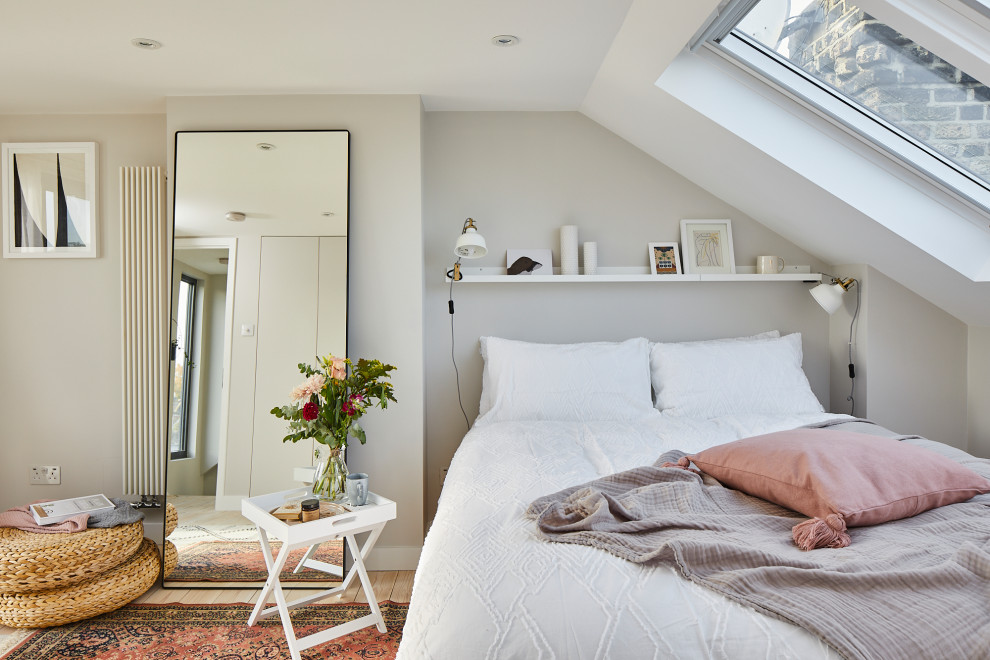 Contemporary bedroom in London with grey walls, light hardwood floors, beige floor and vaulted.