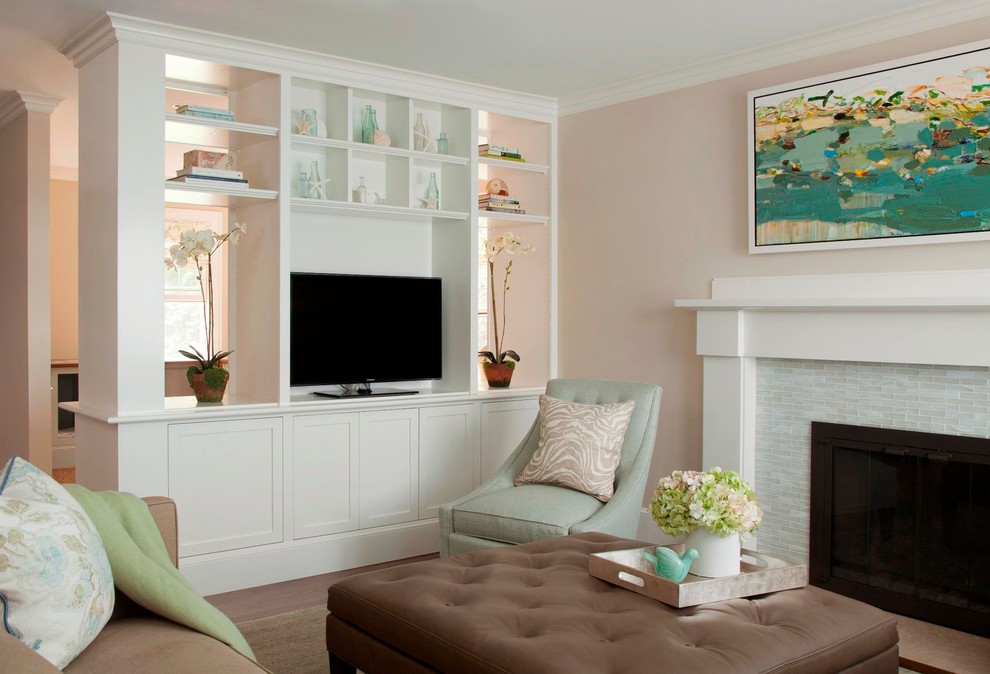 This is an example of a large beach style open concept living room in Boston with pink walls, medium hardwood floors, a standard fireplace, a tile fireplace surround and a built-in media wall.