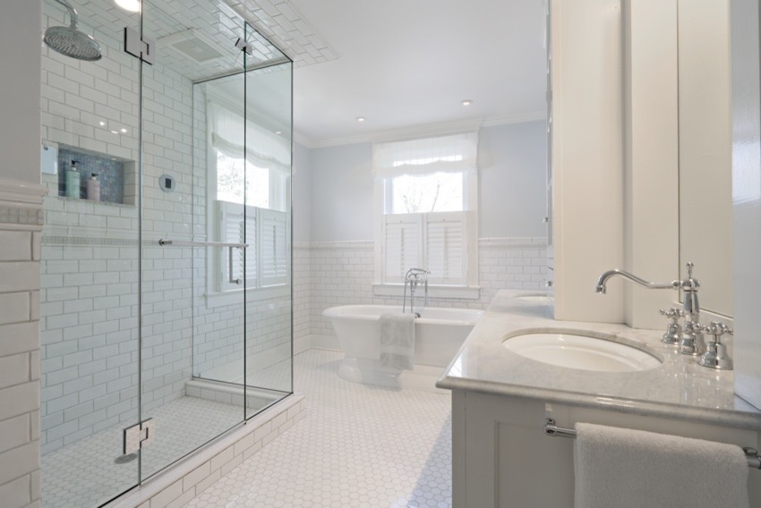 Mid-sized transitional master bathroom in New York with recessed-panel cabinets, white cabinets, a freestanding tub, a corner shower, a two-piece toilet, white tile, ceramic tile, white walls, marble floors, an undermount sink, marble benchtops, white floor, a hinged shower door, blue benchtops, a niche, a double vanity and a built-in vanity.