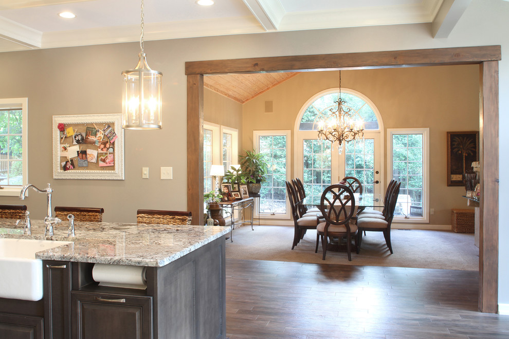 Kitchen/dining room combo - large transitional l-shaped kitchen/dining room combo idea with a farmhouse sink, raised-panel cabinets, dark wood cabinets, granite countertops, yellow backsplash, cement tile backsplash, stainless steel appliances and an island
