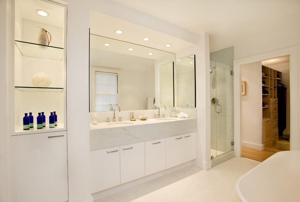 Design ideas for a contemporary bathroom in Boston with an undermount sink, flat-panel cabinets, white cabinets, a freestanding tub, a corner shower, blue tile and subway tile.