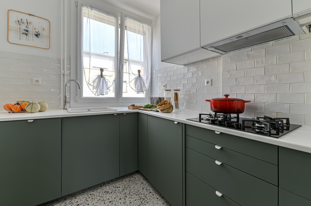 Small contemporary u-shaped enclosed kitchen in Paris with a submerged sink, flat-panel cabinets, green cabinets, laminate countertops, white splashback, terracotta splashback, white appliances, ceramic flooring, no island, multi-coloured floors and white worktops.