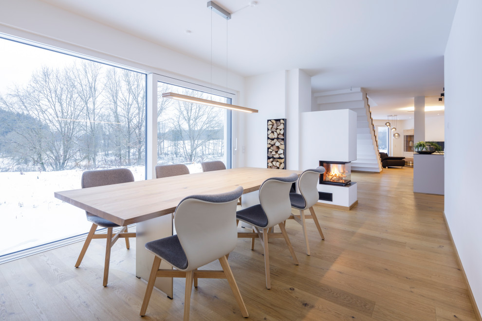 Idées déco pour une salle à manger moderne de taille moyenne avec un poêle à bois et un manteau de cheminée en plâtre.