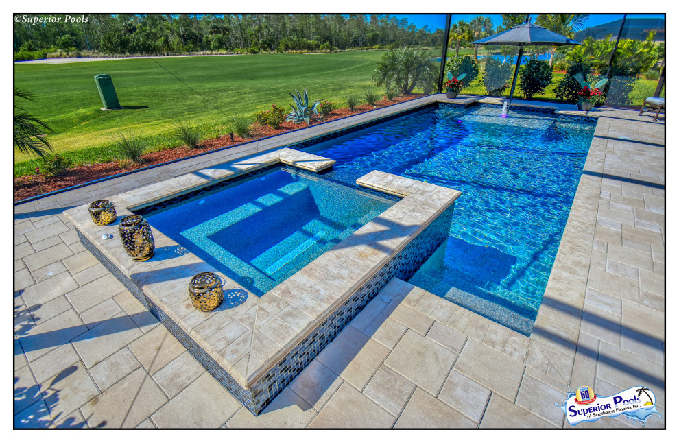 Inspiration for a mid-sized tropical backyard rectangular lap pool in Tampa with a pool house and brick pavers.