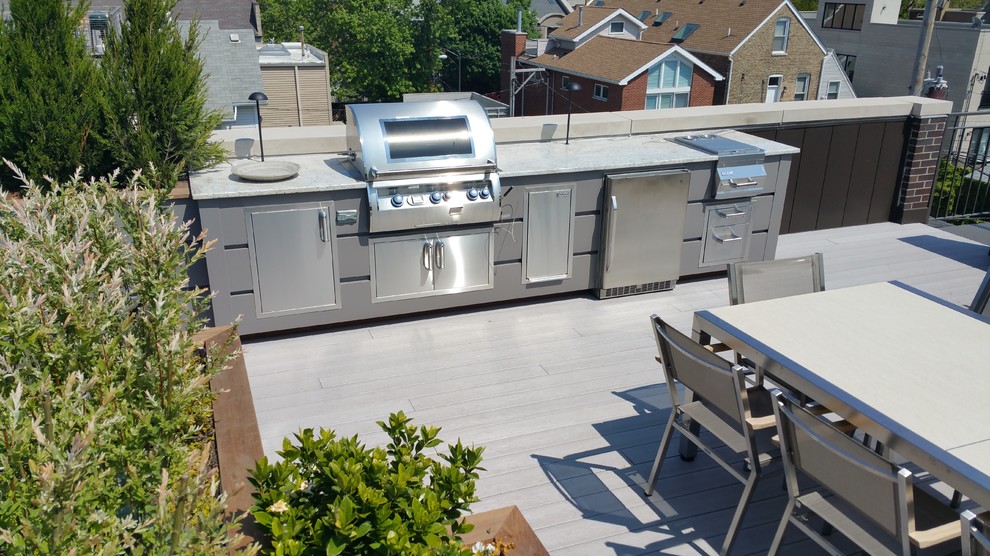 This is an example of a large traditional rooftop deck in Chicago with an outdoor kitchen and a pergola.