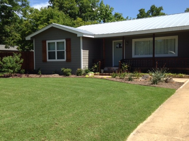 This is an example of a small country sloped full sun xeriscape in Austin with mulch.