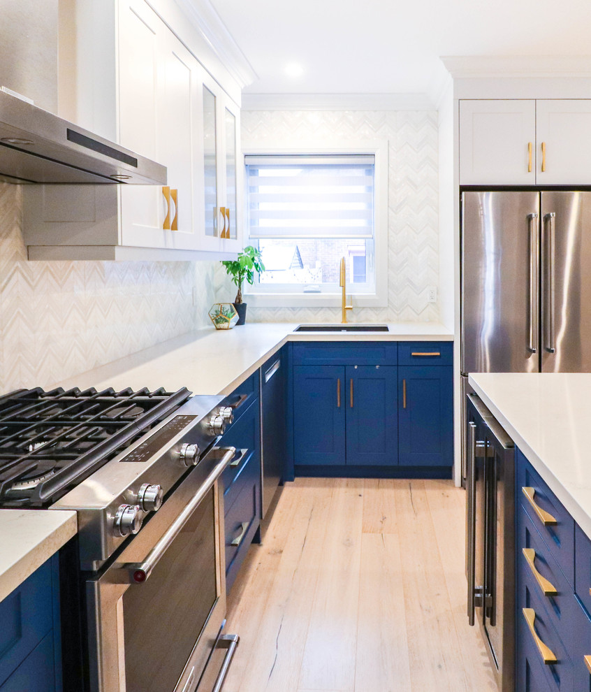 Inspiration for a small transitional l-shaped light wood floor and beige floor eat-in kitchen remodel in Toronto with an undermount sink, shaker cabinets, white cabinets, quartzite countertops, white backsplash, ceramic backsplash, stainless steel appliances, an island and white countertops