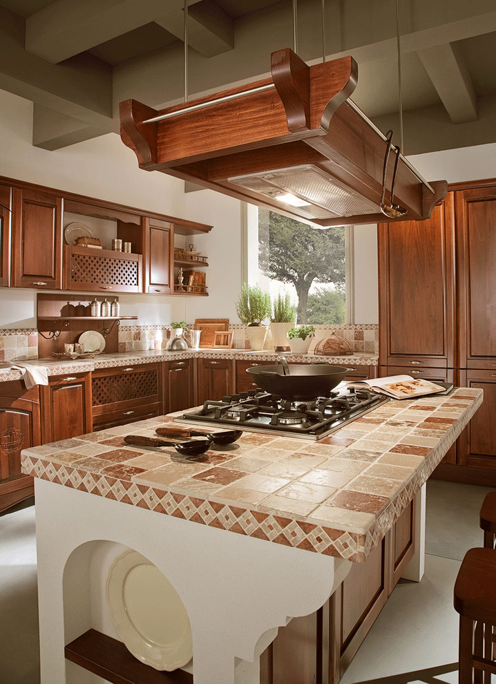 This is an example of a mediterranean kitchen in Miami with raised-panel cabinets, dark wood cabinets, tile benchtops and multi-coloured benchtop.