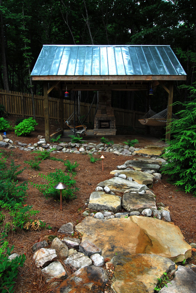 Large mountain style backyard kidney-shaped infinity water slide photo in Atlanta