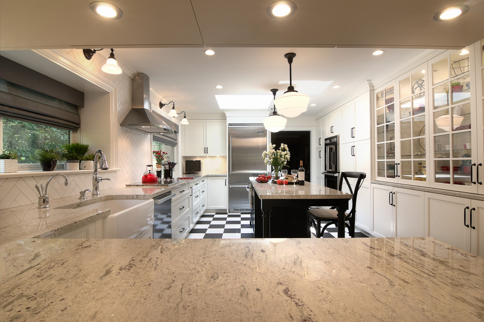 Inspiration for a transitional u-shaped multicolored floor enclosed kitchen remodel with a farmhouse sink, glass-front cabinets, white cabinets, granite countertops, white backsplash, subway tile backsplash, stainless steel appliances, an island and beige countertops