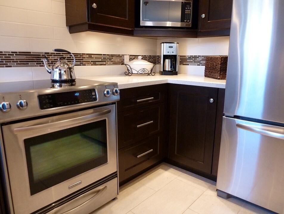 Example of a transitional porcelain tile and beige floor eat-in kitchen design in Toronto with a double-bowl sink, shaker cabinets, dark wood cabinets, quartz countertops, white backsplash, subway tile backsplash, stainless steel appliances and white countertops