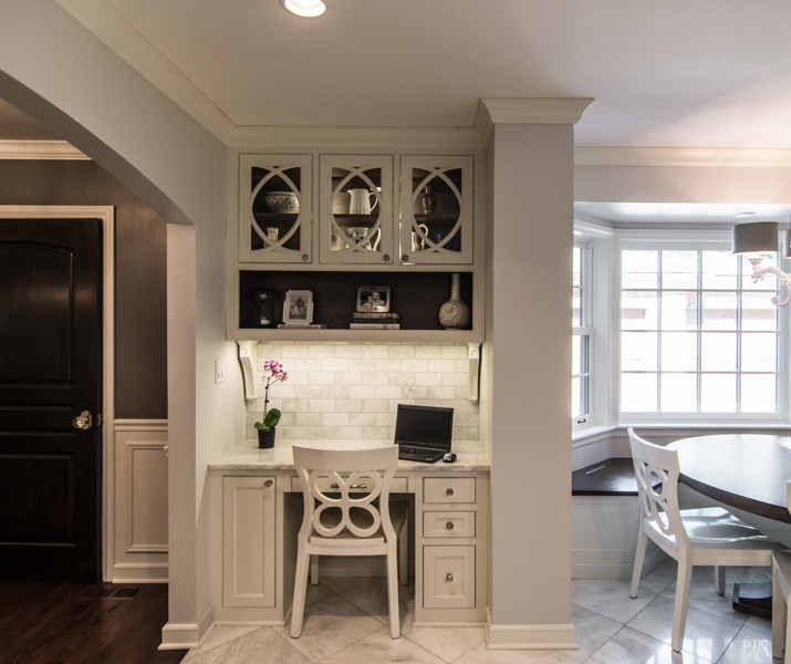 This is an example of a mid-sized traditional eat-in kitchen in Chicago with beaded inset cabinets, white cabinets, marble benchtops, grey splashback, subway tile splashback, marble floors and panelled appliances.