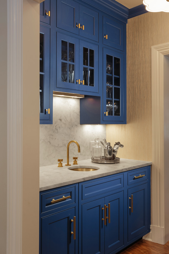 Inspiration for a mid-sized transitional galley wet bar in New York with an undermount sink, recessed-panel cabinets, blue cabinets, marble benchtops, white splashback, marble splashback, medium hardwood floors and brown floor.