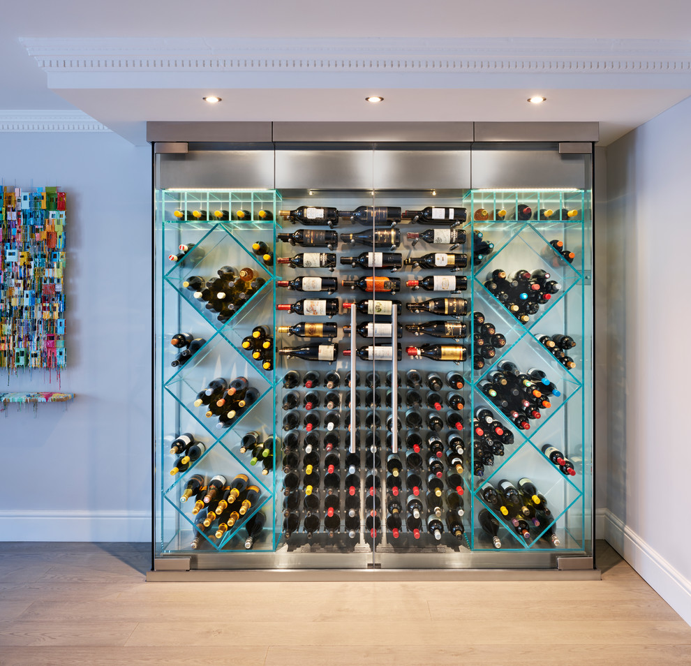 This is an example of a contemporary wine cellar in Other with light hardwood floors, diamond bins and beige floor.
