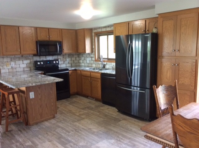 Example of a mid-sized linoleum floor and beige floor kitchen design with an undermount sink and stainless steel appliances