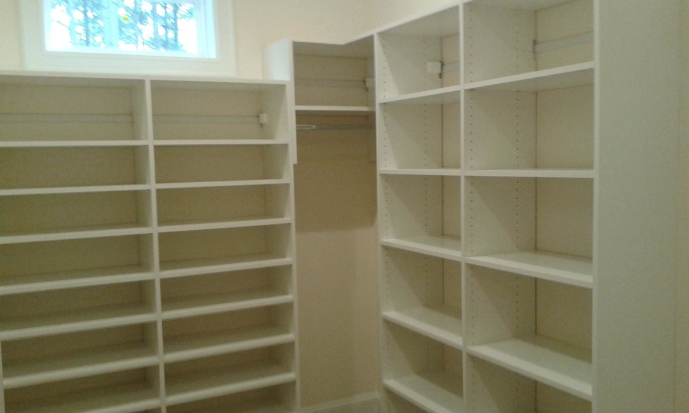 Photo of a small modern gender-neutral walk-in wardrobe in Other with open cabinets, white cabinets and carpet.