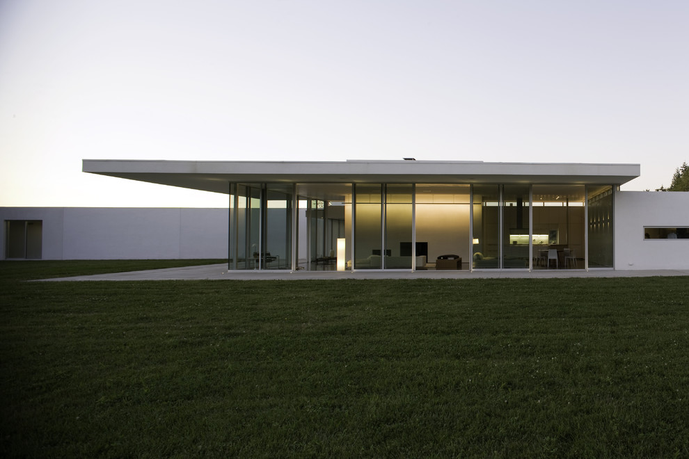 Modern one-storey stucco white house exterior in Other with a flat roof.