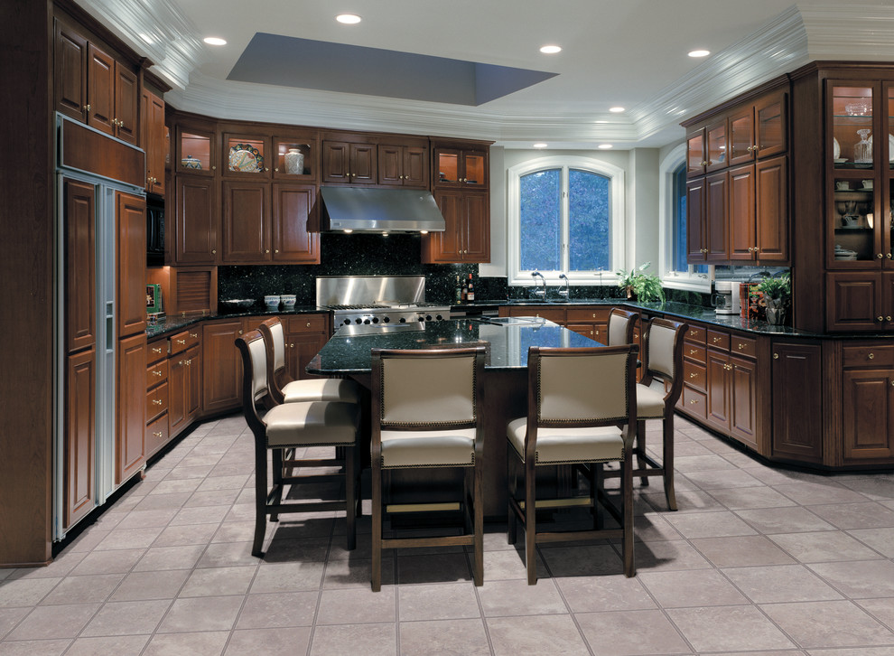 Example of a transitional u-shaped kitchen design in Miami with raised-panel cabinets, dark wood cabinets, granite countertops, paneled appliances and an island