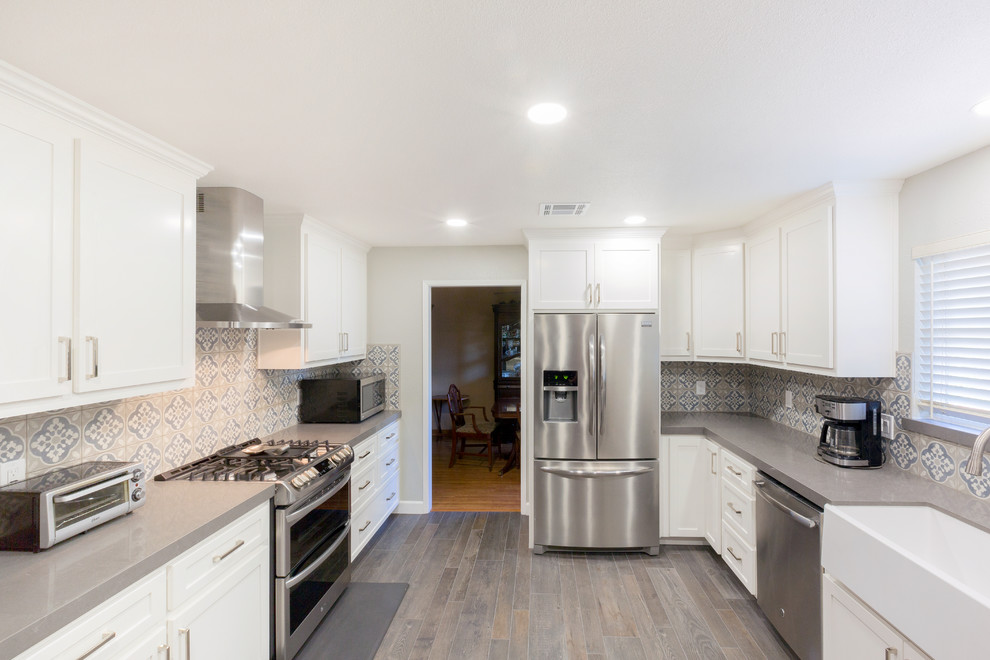 Photo of a contemporary single-wall eat-in kitchen in Sacramento with a farmhouse sink, white cabinets, quartzite benchtops, mosaic tile splashback, stainless steel appliances, no island and grey benchtop.