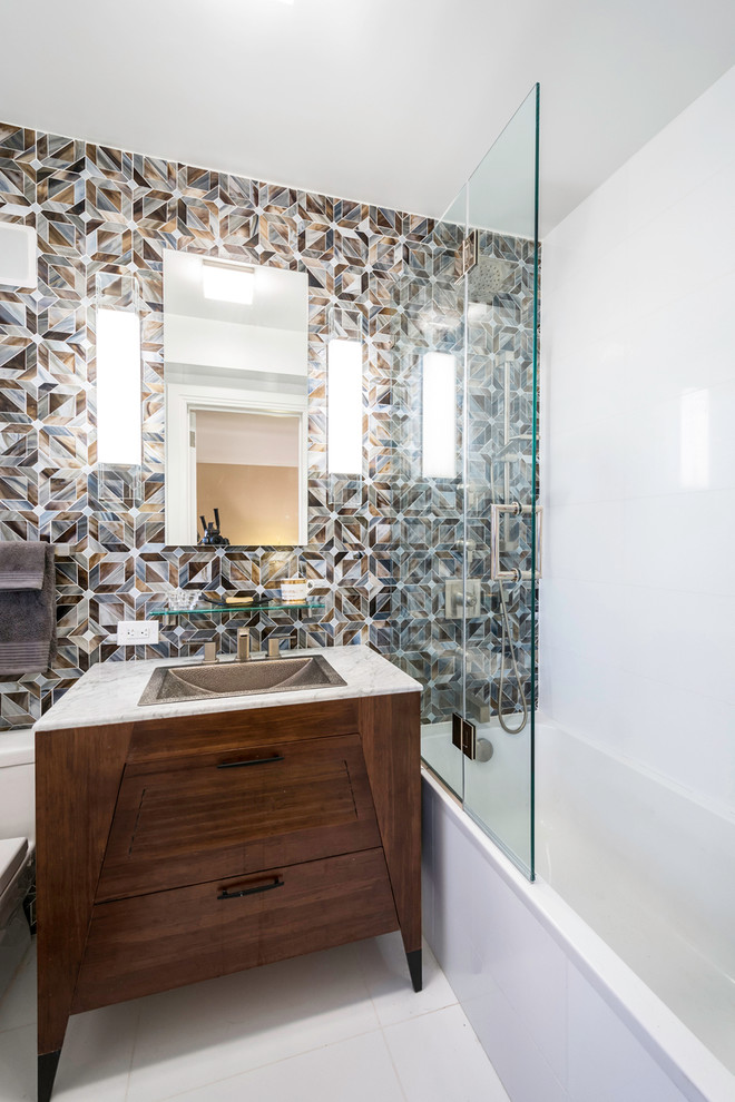 Photo of a mid-sized contemporary 3/4 bathroom in New York with white walls, ceramic floors, flat-panel cabinets, dark wood cabinets, a freestanding tub, an open shower, a two-piece toilet, brown tile, gray tile, mosaic tile, a drop-in sink and marble benchtops.