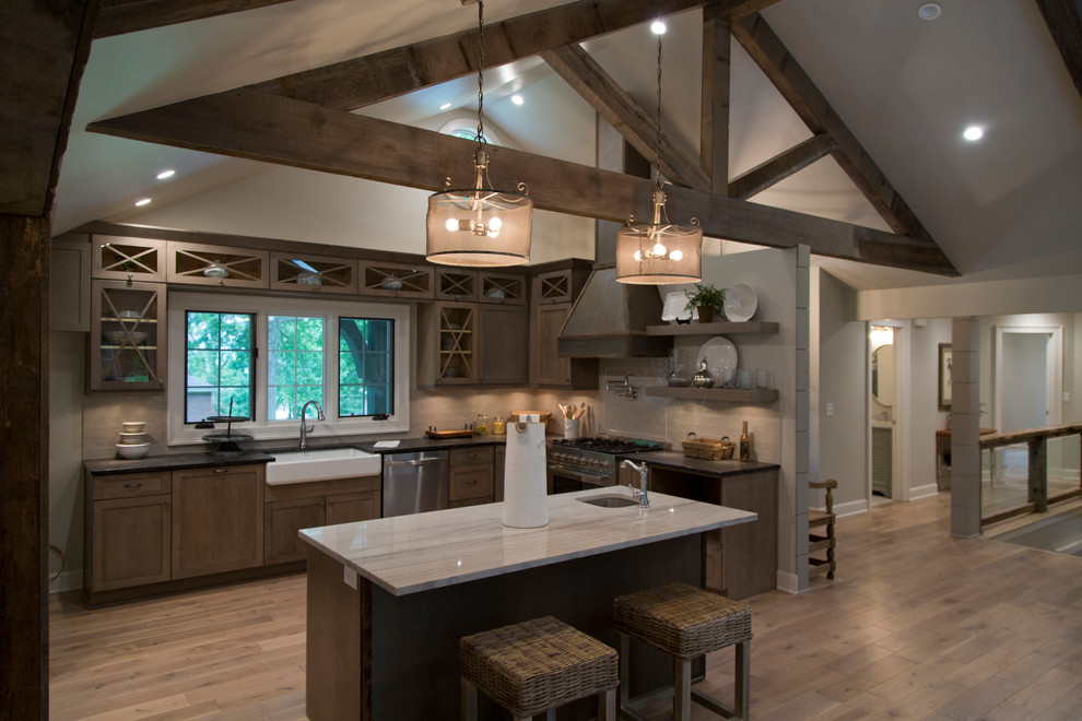 Design ideas for a large country l-shaped open plan kitchen in Kansas City with a farmhouse sink, glass-front cabinets, medium wood cabinets, granite benchtops, beige splashback, stainless steel appliances, medium hardwood floors, with island and brown floor.