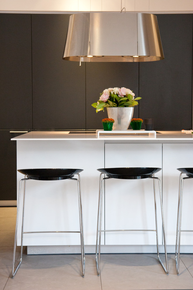 Photo of a mid-sized contemporary galley eat-in kitchen in Paris with with island and black cabinets.
