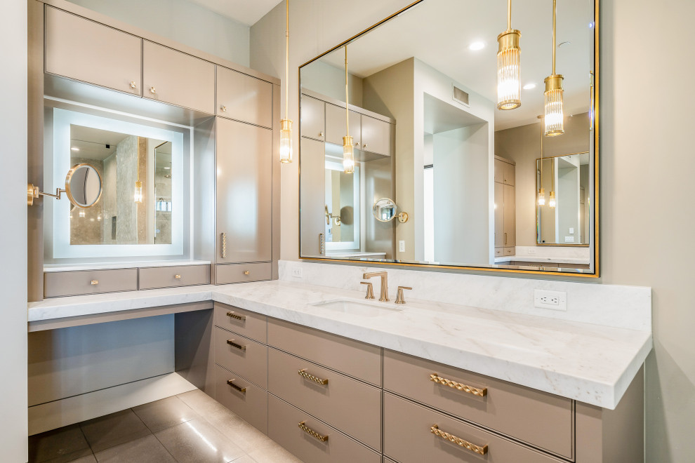 This is an example of an expansive contemporary master bathroom in Phoenix with flat-panel cabinets, beige cabinets, a freestanding tub, an open shower, a one-piece toilet, white tile, stone slab, beige walls, porcelain floors, a drop-in sink, limestone benchtops, brown floor, an open shower, white benchtops, an enclosed toilet, a double vanity, a floating vanity, vaulted and panelled walls.