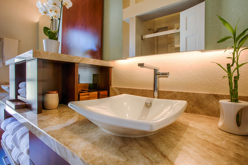Example of a small transitional beige tile and porcelain tile porcelain tile and beige floor alcove bathtub design in Phoenix with flat-panel cabinets, medium tone wood cabinets, a one-piece toilet, beige walls, a vessel sink and granite countertops