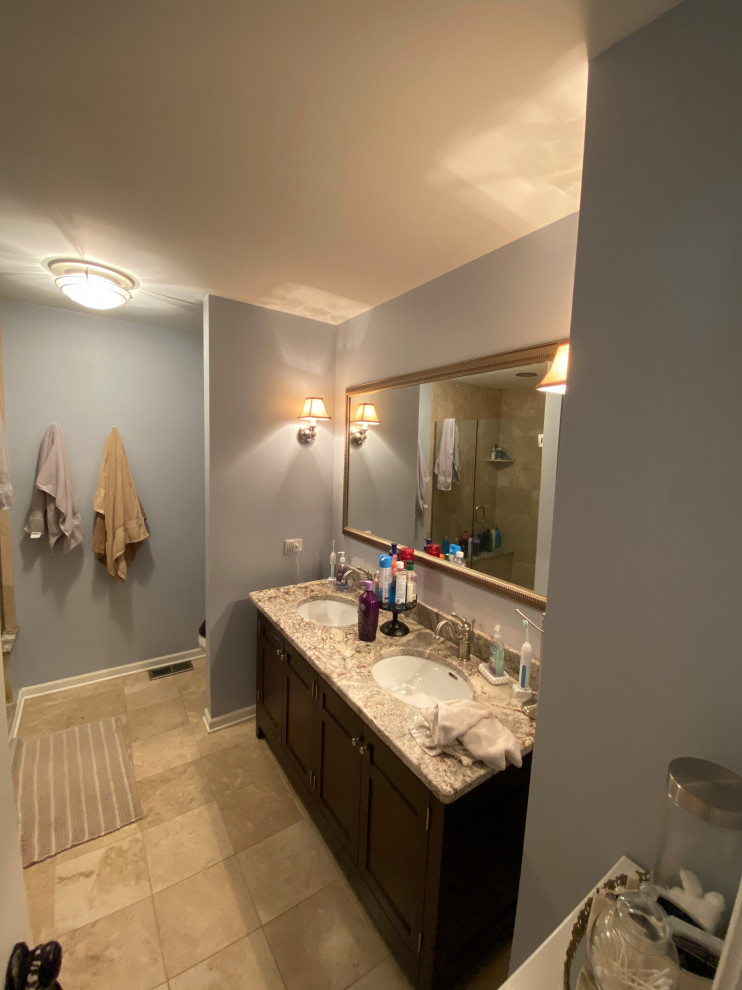 Idéer för att renovera ett mellanstort lantligt flerfärgad flerfärgat en-suite badrum, med luckor med upphöjd panel, skåp i mörkt trä, ett hörnbadkar, en dubbeldusch, en toalettstol med hel cisternkåpa, grå kakel, marmorkakel, vita väggar, mörkt trägolv, ett konsol handfat, granitbänkskiva, brunt golv och dusch med gångjärnsdörr
