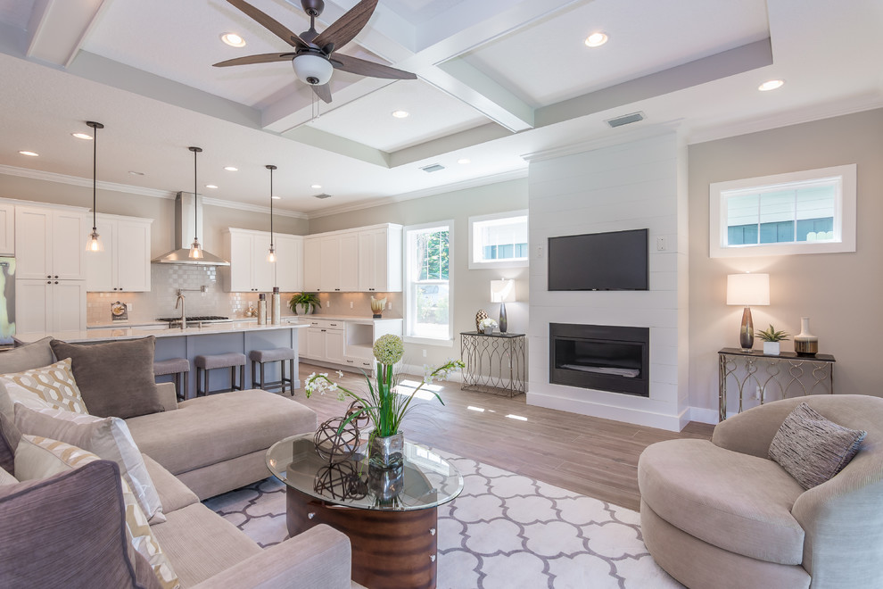 Inspiration for a large country open concept family room in Orlando with beige walls, ceramic floors, a standard fireplace, a wood fireplace surround, a wall-mounted tv and beige floor.