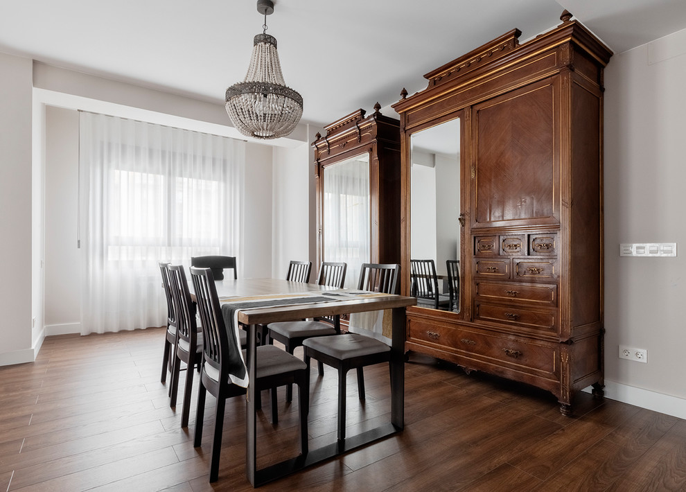 Diseño de comedor tradicional renovado grande sin chimenea con paredes beige, suelo laminado y suelo marrón