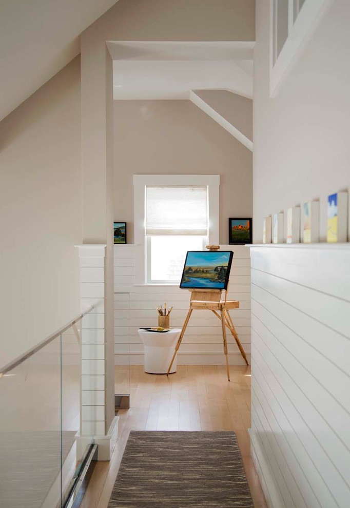 Example of a beach style light wood floor hallway design in Boston with beige walls