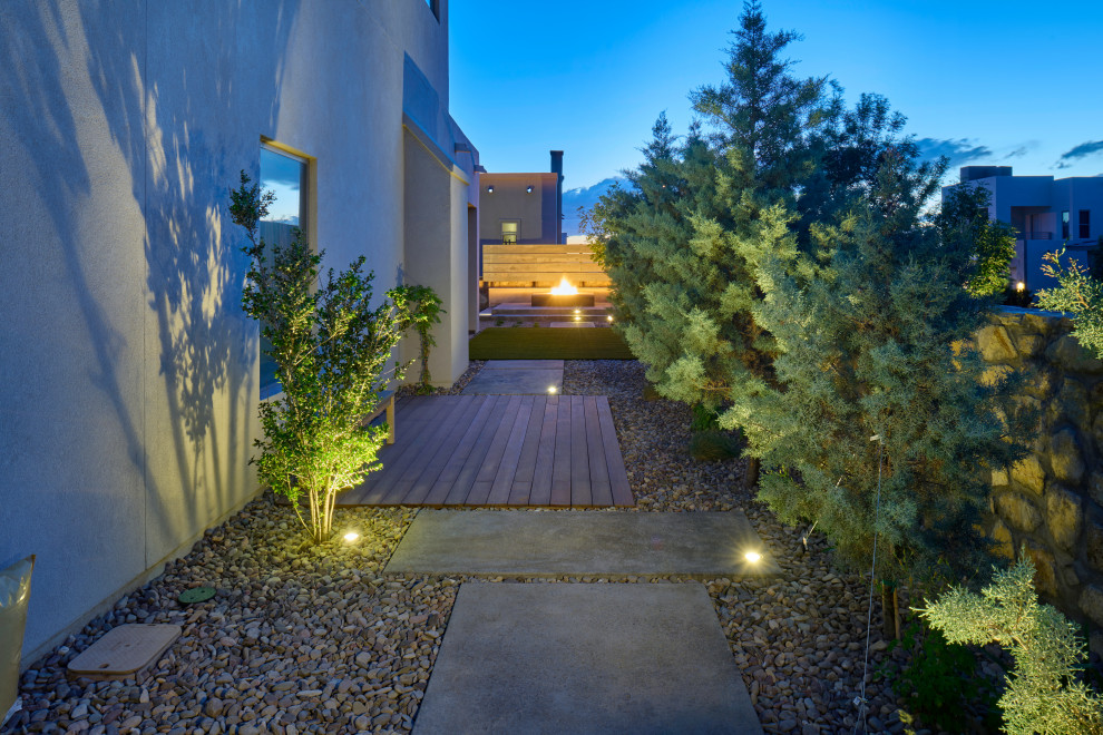 На фото: маленький засухоустойчивый сад на боковом дворе в современном стиле с дорожками, мощением тротуарной плиткой и с деревянным забором для на участке и в саду