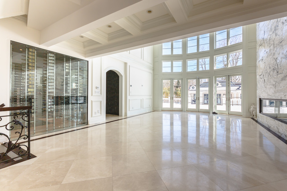 Example of a huge minimalist marble floor wine cellar design in New York with display racks